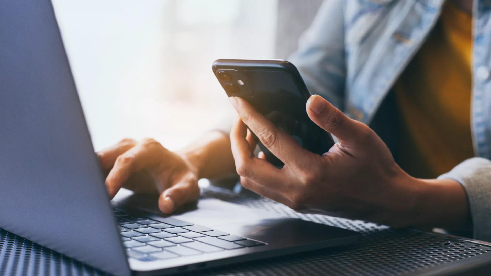 Photo of person using laptop and phone