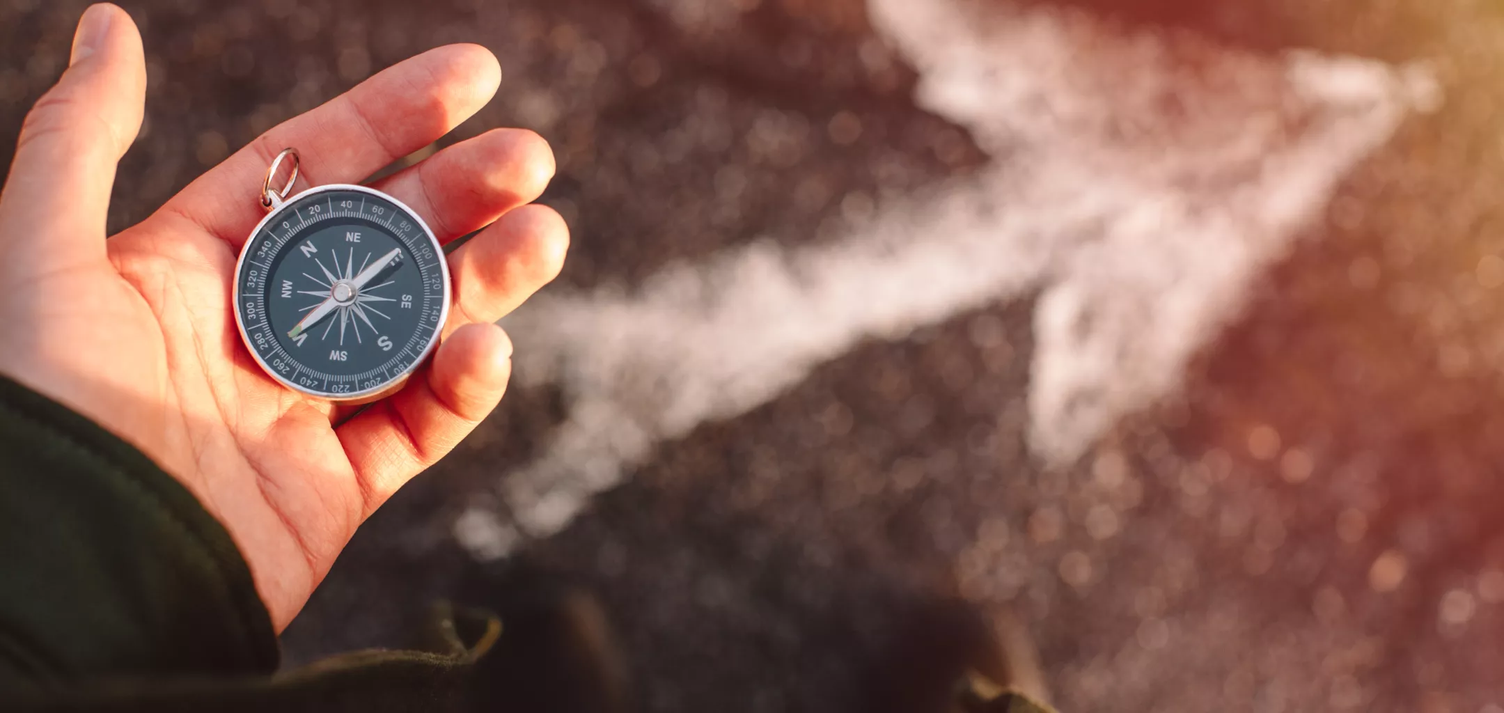 traveler holding compass in the hand making choice in what direction to go